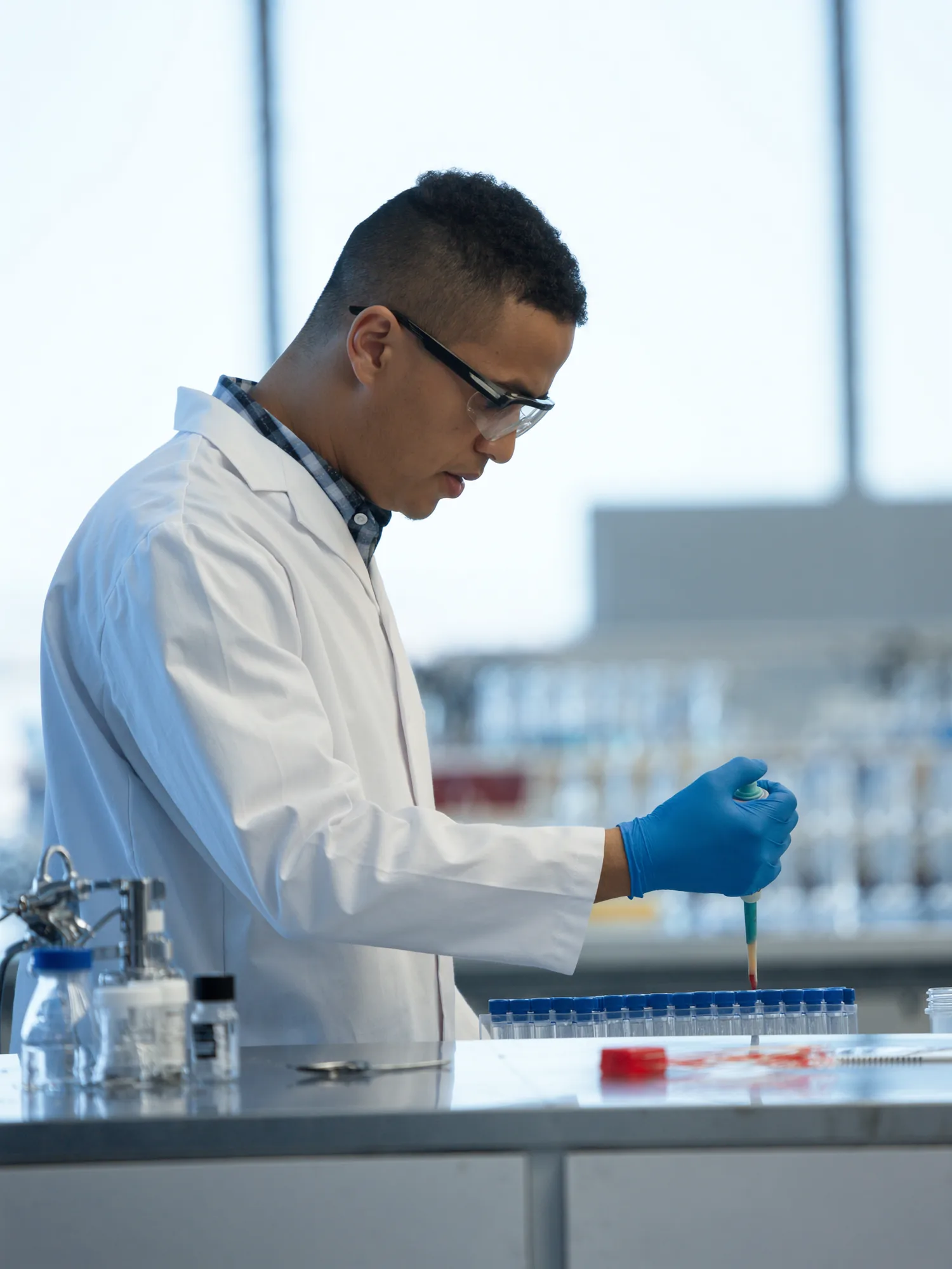 A pharmaceutical scientist dispensing samples into vials in a modern quality-control laboratory